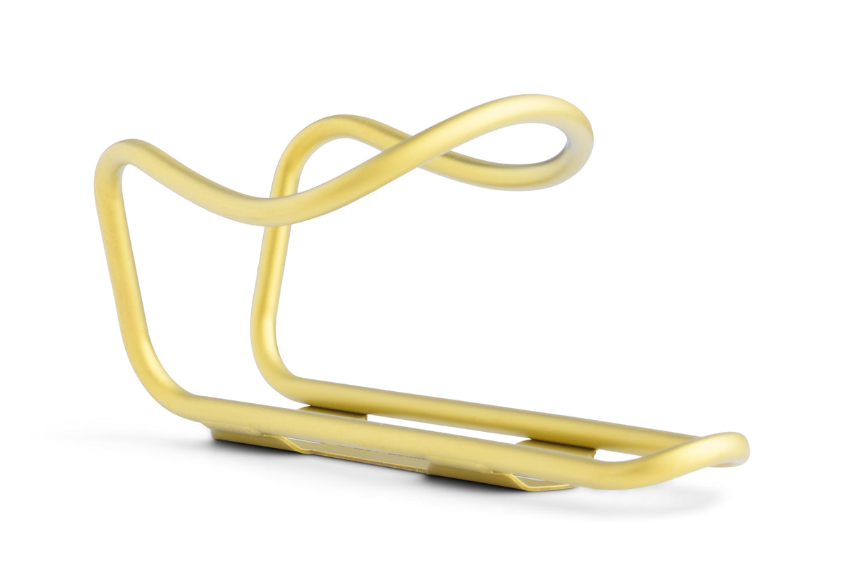A minimalist, curved metallic bicycle water bottle cage in a brushed gold finish, shown on a clean white background.