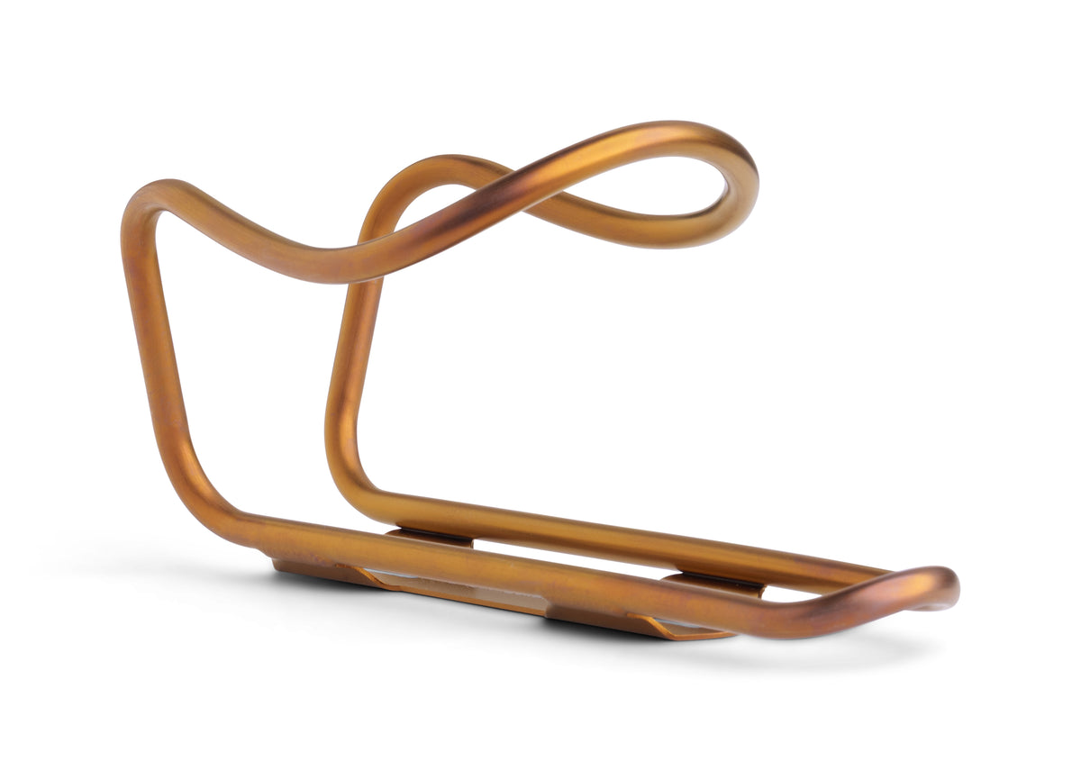 A copper-colored bicycle water bottle cage with a curved, looped design, shown on a clean white background.