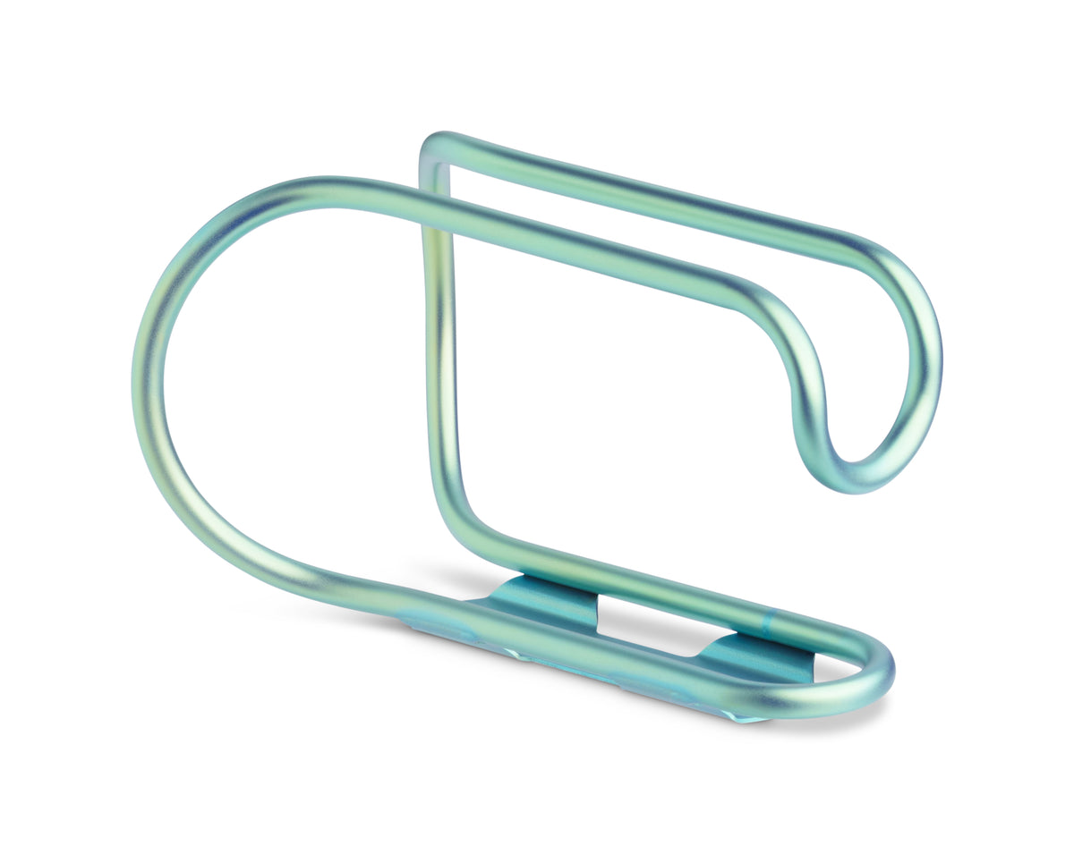 A metallic bicycle water bottle cage with a curved, looped design, finished in a light teal-blue anodized finish, shown on a plain white background.